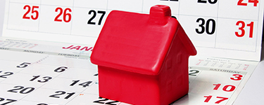 Red plastic toy house on a calendar