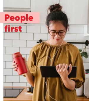 Photo of a woman looking at a tablet in her kitchen