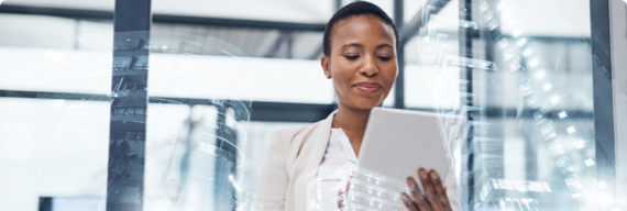 Photo d’une femme consultant une tablette dans un bureau vitré au centre-ville