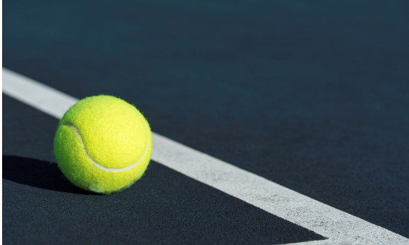 Photo of a tennis ball on a tennis court