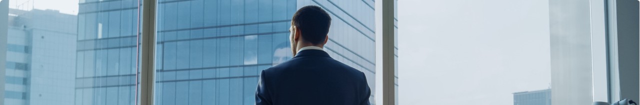 Photo of a man in front of a window inside an office building