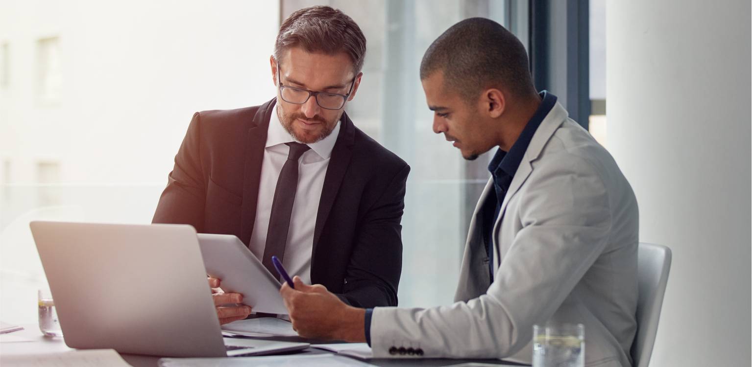 Photo of two people looking at documents in an office  