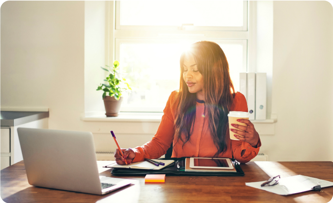 Photo of a person working at a desk in a sunny office 