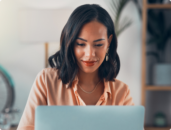 Photo of a woman wearing professional clothing working on her laptop