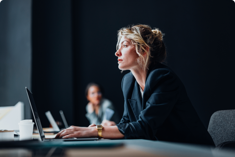 Photo of a person on their computer overseeing corporate cybersecurity