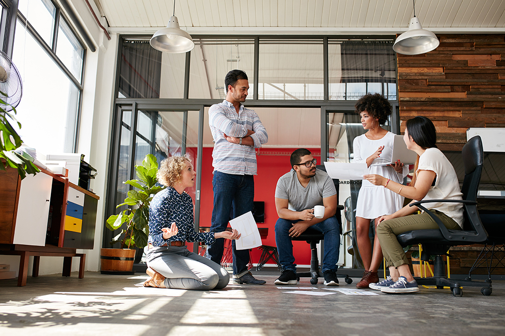  A group of people sitting in an office, exchanging ideas.