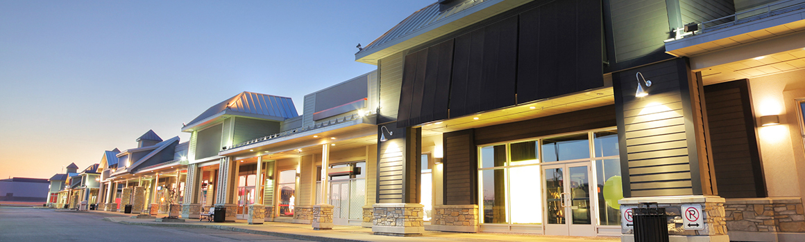 A row of shops illuminated by soft lights at dusk