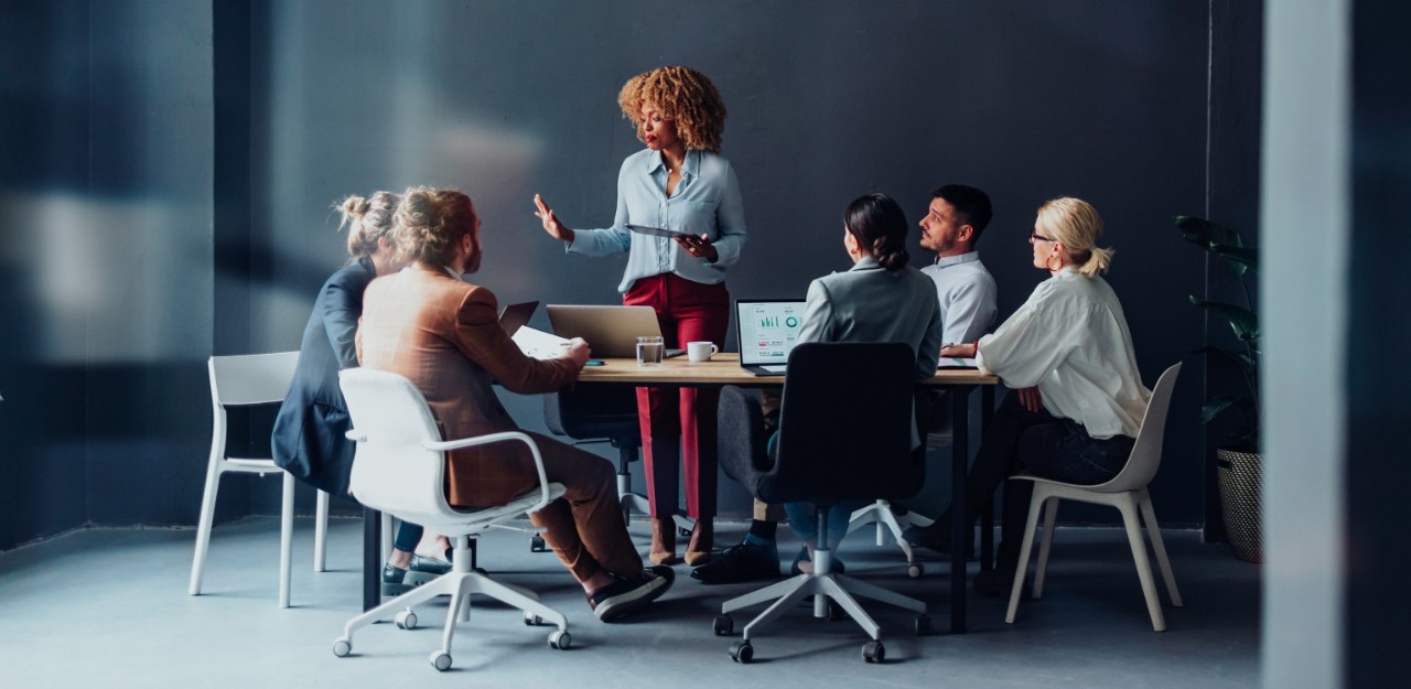 Photo of a person presenting something to their colleagues at an office 