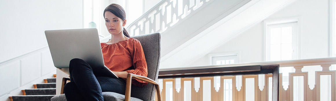 Beautiful Woman Working on Laptop in Bright Living Room
