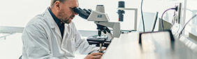 Researcher looking through a microscope