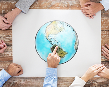 Image of hands on top of a drawing of the Earth