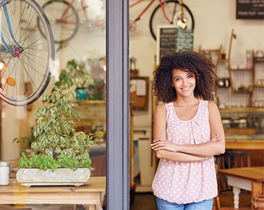 A woman smiling in front of a store