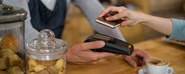 Woman paying bill through smartphone using NFC technology