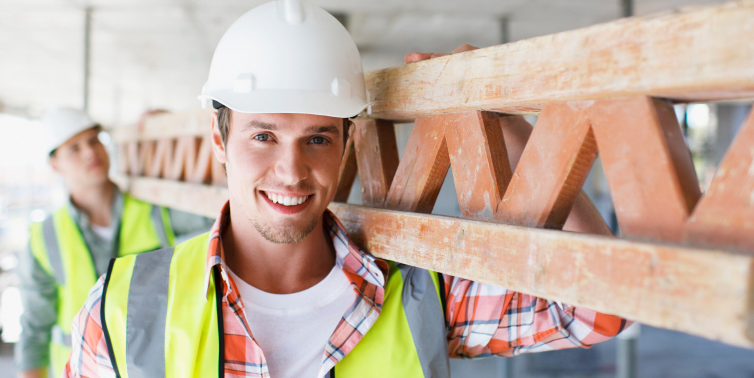 Photo of two people wearing a construction helmet and beam