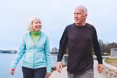 Retired couple walking alongside a river 