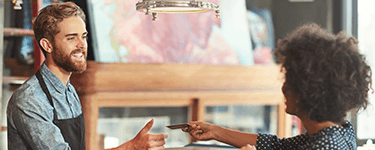 Woman gives her card to a smiling cashier