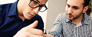 Two men looking at the same desk