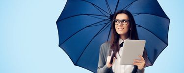 Smiling woman standing under an umbrella holding a tablet