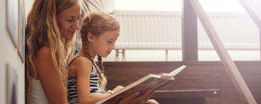 Woman reading a book with her daughter