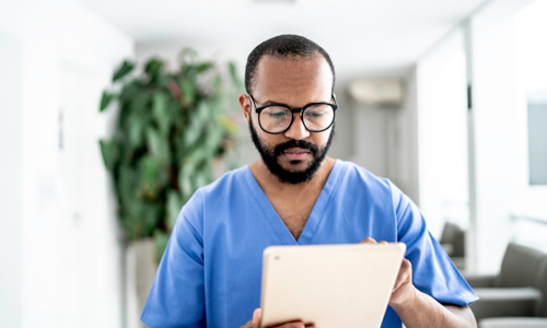 Photo d'un homme en uniforme médical consultant une tablette