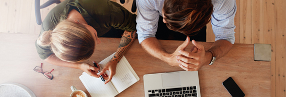 Couple talking with notebook and laptop