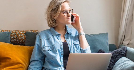 Woman speaking on the phone with laptop on her lap