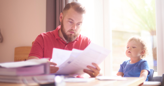 Yound child looks at a man sorting his papers