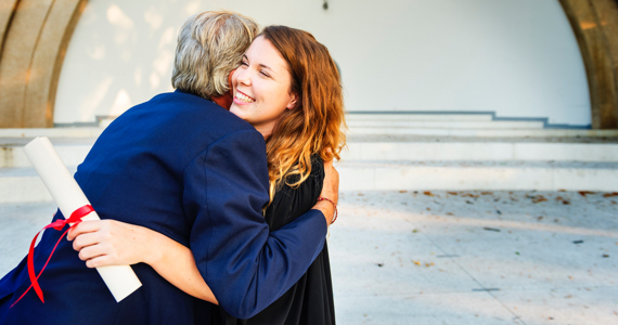 Man hugs a young female graduate