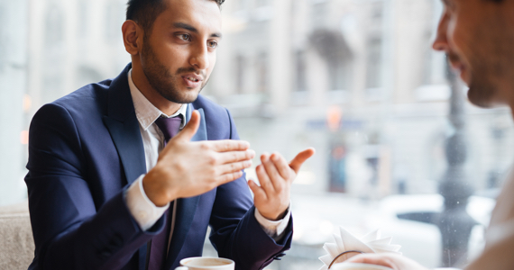 Young professional man explains something by making a hand gesture