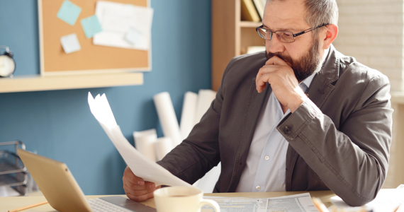 Man reading a document at his desk