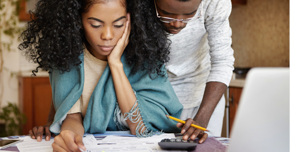 Young man and young woman do their accounting with a calculator