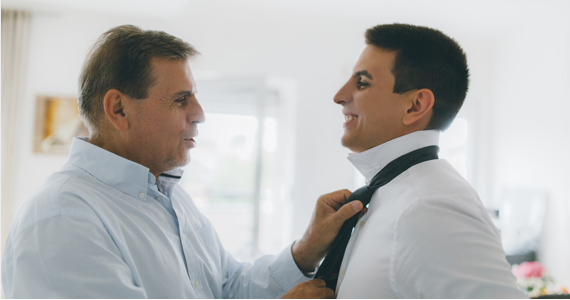 Man knots the tie of a younger man