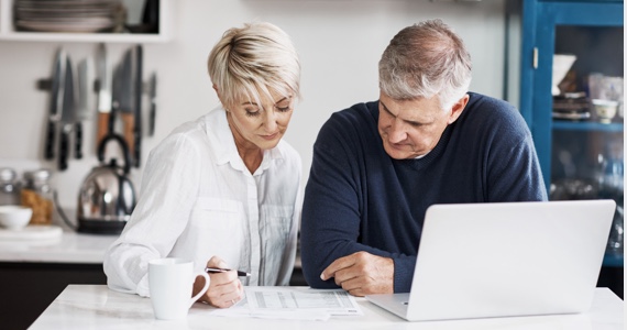 Couple looks at a document on a kitchen counter