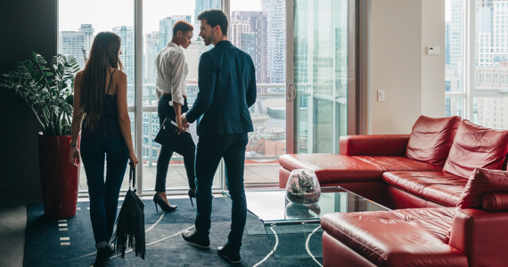 Three professionals in an office with a city view