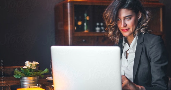 Young professional woman smiles while working at her computer