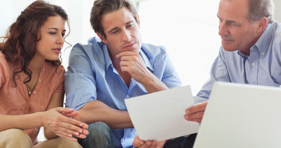 Advisor shows a document to a young couple