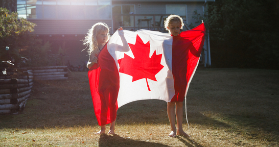 Two children holding a Canadian flag