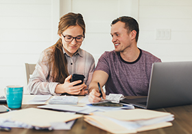 Couple chatting behind a laptop