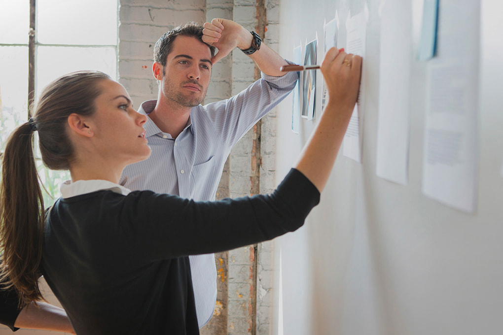 Two people writing on a board