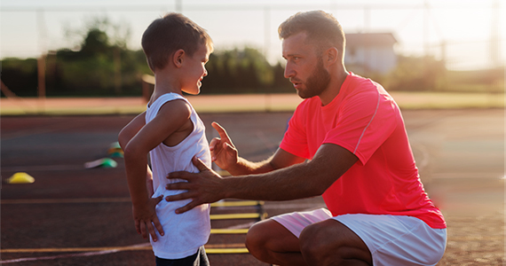 A gym teacher offering advice to a child.