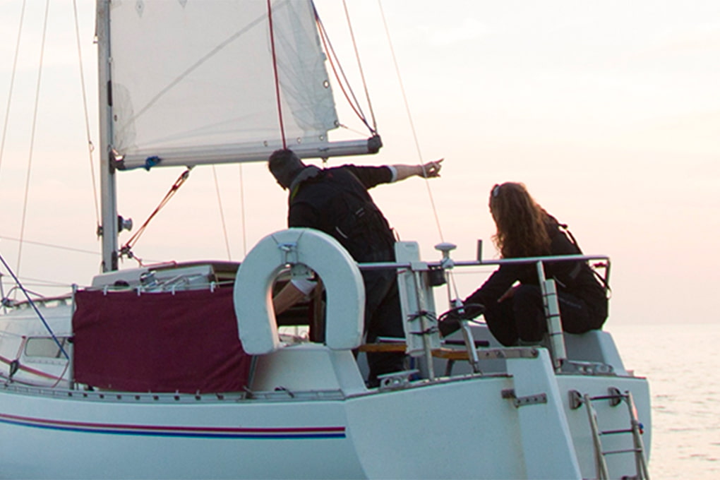 Photo of a couple on a sailboat at sunset