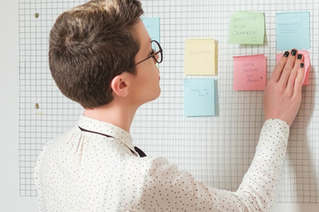 Young woman working in front of a memo board