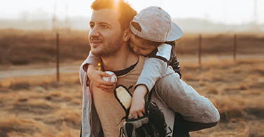 Man carrying his child on his back 
