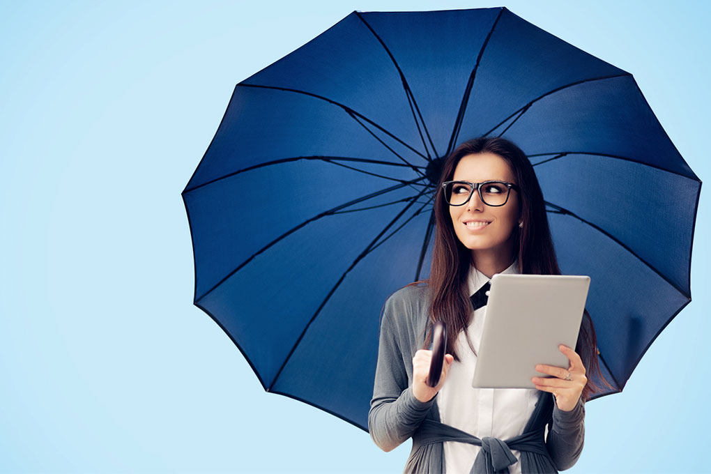 Photo of a student holding an umbrella and a tablet 