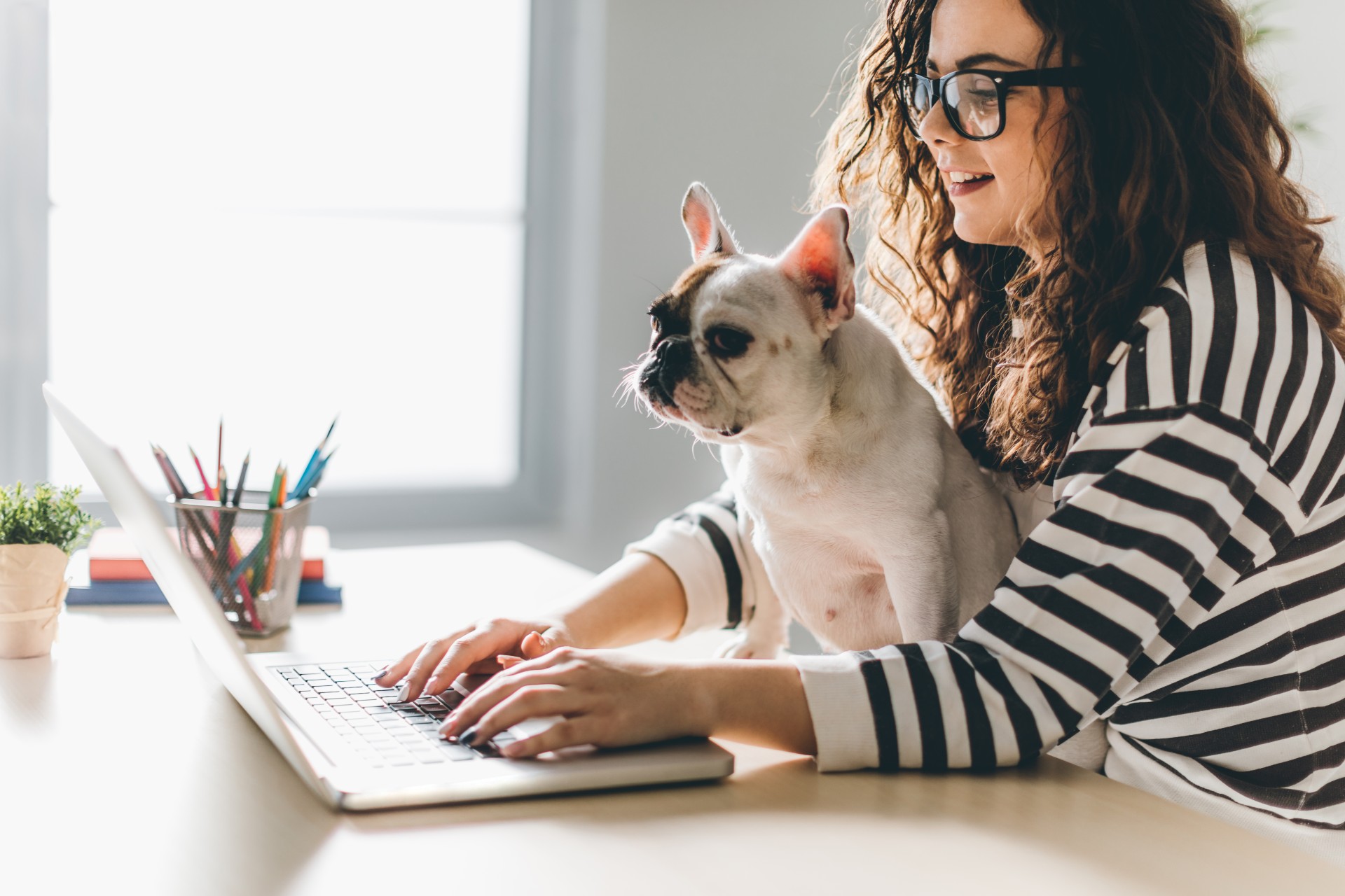 Woman with dog in front of her computer