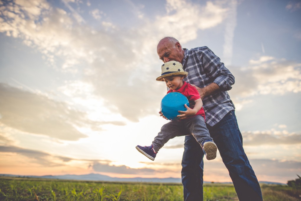 Photo of a grandpa lifting up his grandson 