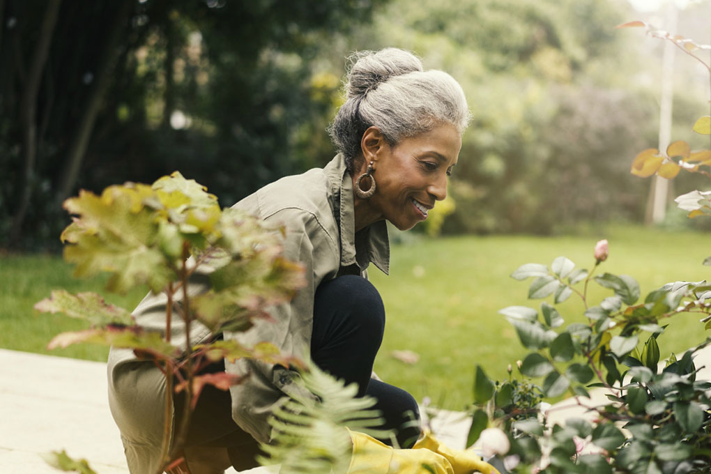 Lady reflecting on her retirement plan while gardening. 