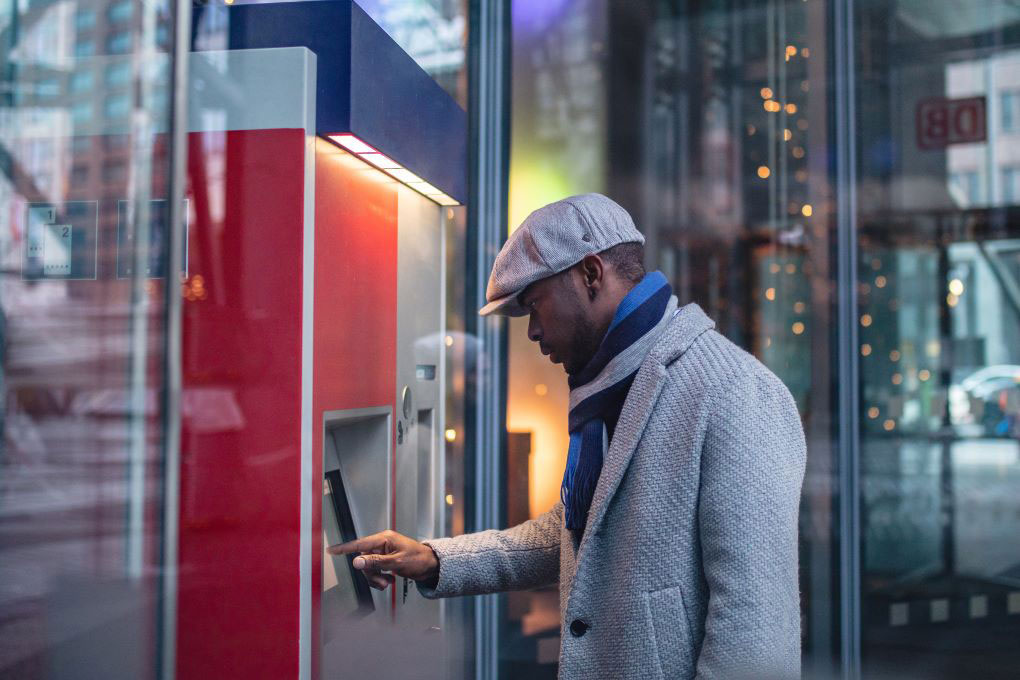 Photo of a man making a transaction at an ABM 