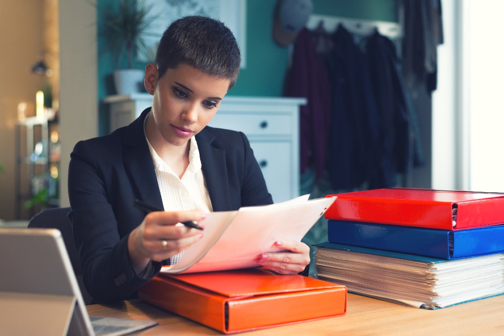 img-accountant-office-labor-woman-business-1020x680 A female accountant reviews tax documents to prepare her company’s taxes.