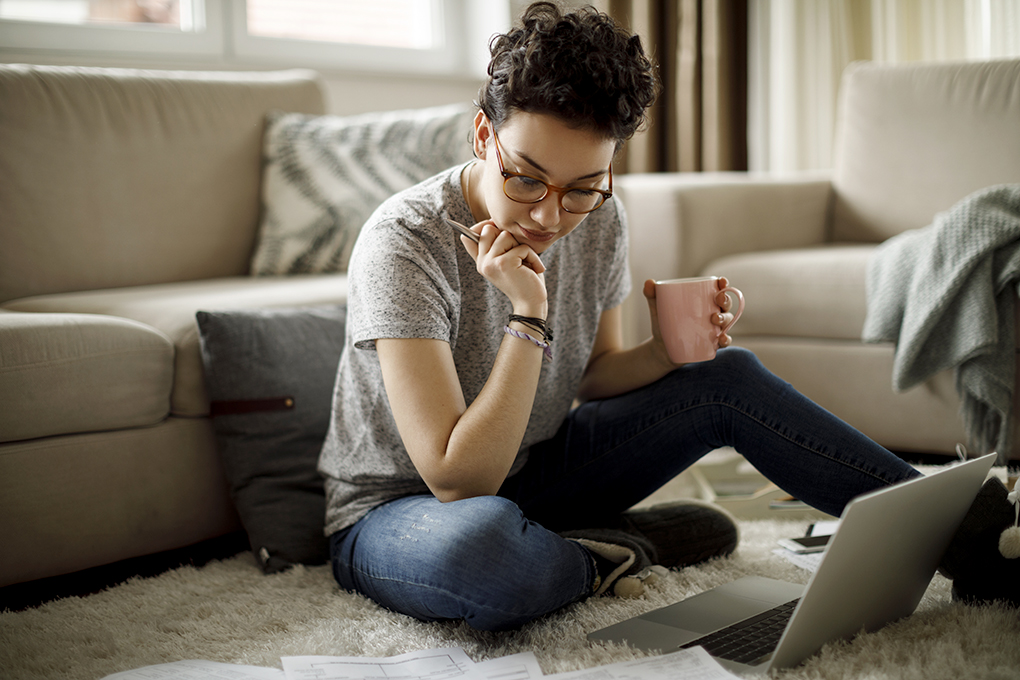 Personal Finance: How to Manage Your Money Family budget and finances. Serious woman doing accounts and feeling frustrated with amount of monthly expenses. Young female wearing glasses calculating utility bills, sitting at kitchen table